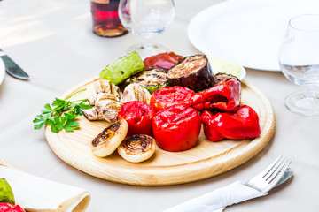 grilled vegetables and mushroom with sauce on a wooden board