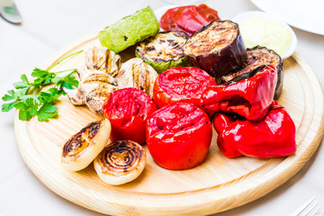 grilled vegetables and mushroom with sauce on a wooden board