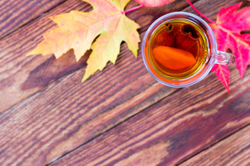 tea with lemon and cinnamon in a glass glass and red autumn leav