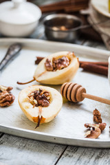Fototapeta premium spicy baked pear with walnuts, honey, cinnamon sticks, healthy d