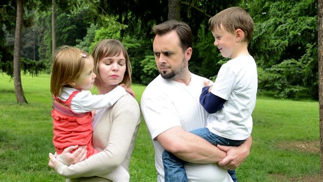 unhappy middle age couple argue in park - children (cute girl and little boy)