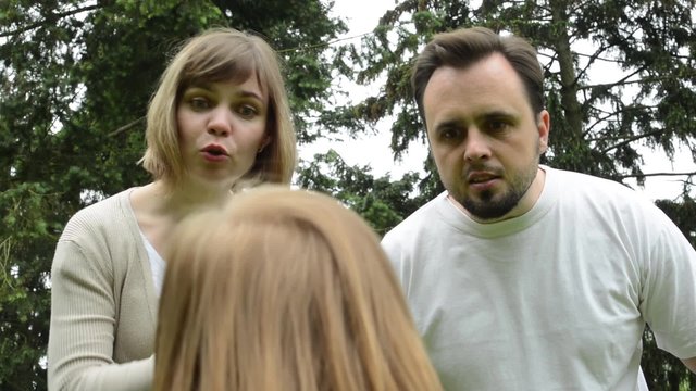Parents (middle age couple) are angry at a child (girl) - park