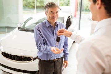 Businessman giving car key to a customer