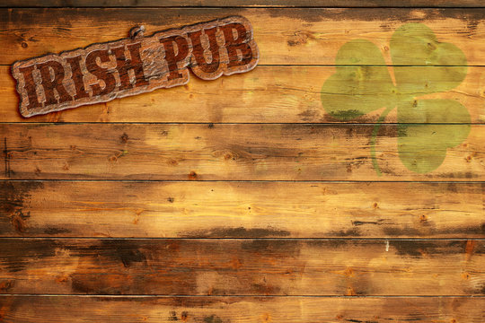 irish pub label and green shamrock on wooden background
