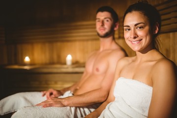 Obraz na płótnie Canvas Happy couple enjoying the sauna together