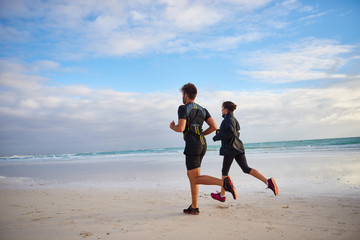 Friends jogging on the beach together
