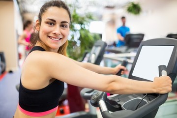 Fototapeta premium Smiling woman on the exercise bike