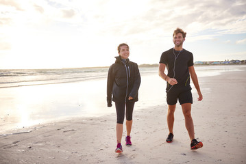 Sporty friends walking on the beach together