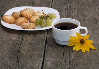 plate with cookies, a cup of coffee and a yellow flower, a still