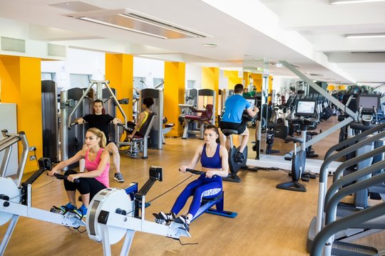 Fit people working out using machines