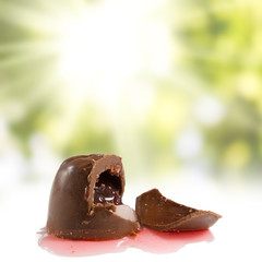 image of delicious chocolates with a cherry on a green background