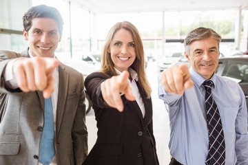 Group of smiling business team pointing together