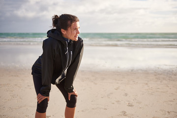 Woman on a tranquil beach taking a rest from her run