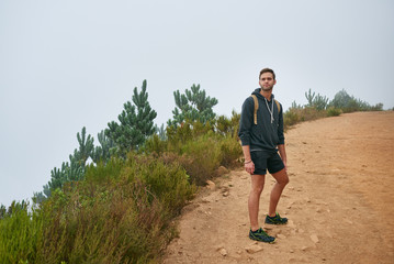 Male hiker looking back at the view while on a nature trail