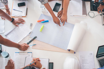 Team of architects people in group on construciton site check documents and business workflow upper view