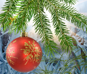 Christmas ball on  winter window background