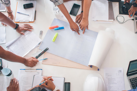 Team of architects people in group on construciton site check documents and business workflow upper view