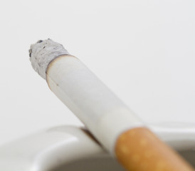 A blurry lit cigarette on a white background