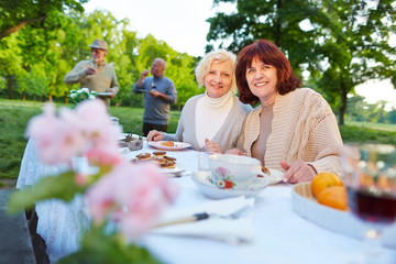 Senioren feiern im Garten mit Kuchen