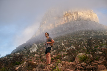 Obraz premium Young hiker on a nature trail with a mountain behind him