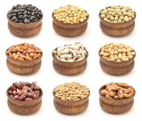 Collection of beans, pinto beans, soya, chickpeas etc. in wooden bowls, isolated on white