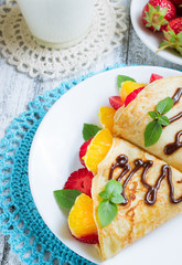 Pancakes with sliced strawberries and orange