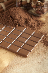 Homemade candy - chocolate, cocoa and cinnamon sticks on paper b