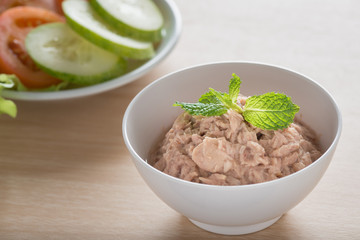 Canned tuna with vegetable on wooden background.