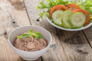 Canned tuna with vegetable on wooden background.