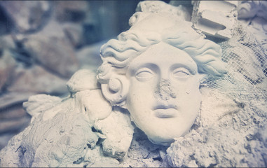 broken sculpture. plaster mask in the trash