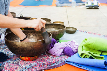 Fototapeta na wymiar Hand playing tibetan bowls outdoors.