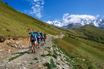 Group of tourists with large backpacks are on mountain