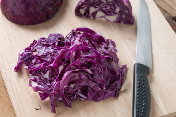 Chopped red cabbage on wooden cutting board.