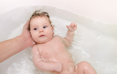 Newborn baby girl taking a bath