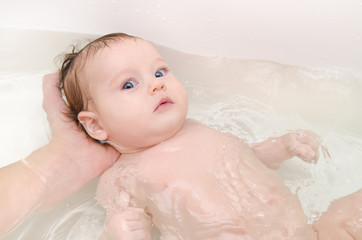 Newborn baby girl taking a bath