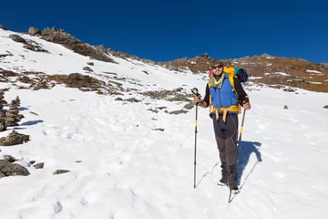 Fotobehang Backpacker mountaineer man standing rest snow mountain. © subbotsky