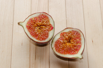 Halved juicy fig on wooden background
