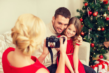 mother taking picture of father and daughter