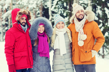 group of smiling men and women in winter forest