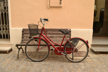 Fototapeta na wymiar Rotes Fahrrad vor alter Holzbank