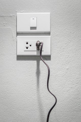 Black plug plugged in a socket.