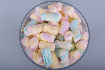 marshmallow candies in different colors on a gray background. top view. entertainment for children in celebration. dessert without lactose and gluten. additive in hot drinks.