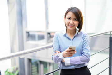 Asian businesswoman talking on a mobile phone at the office