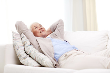 happy senior woman resting on sofa at home