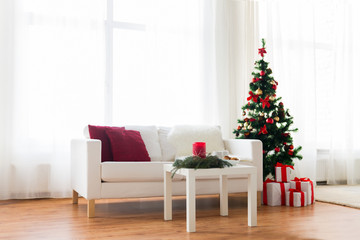sofa, table and christmas tree with gifts at home