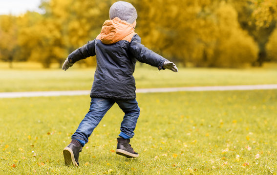 little boy running outdoors