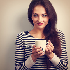 Cute young casual woman holding in hand cup of tea. Vintage tone