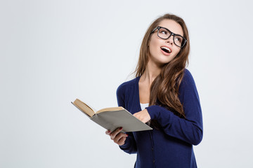 Pretty female student holding book and looking away