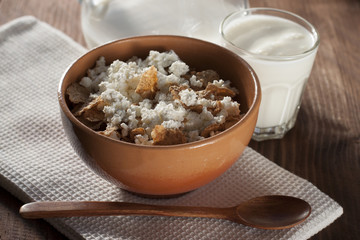 Cottage cheese with cereals in clay and glass salad bowl with yo