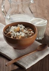 Cottage cheese with cereals in clay and glass salad bowl with yo
